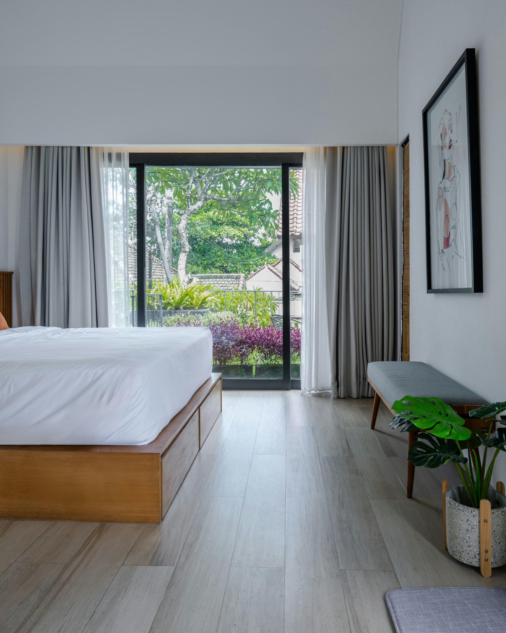 Bedroom with large window and wooden floor